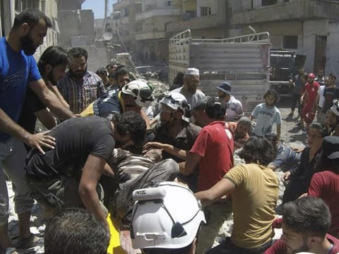 Syrian White Helmet civil defence workers and civilians carry an injured man on a stretcher after an airstrike hit the northern town of Ariha, in Idlib province, Syria, on July 28, 2019.