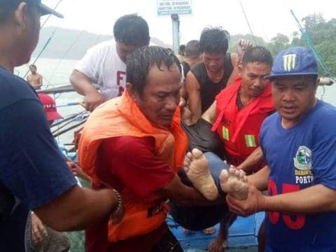 Fishermen carrying a dead body  after a boat accidents that happened in Iloilo-Guimaras Strait.  