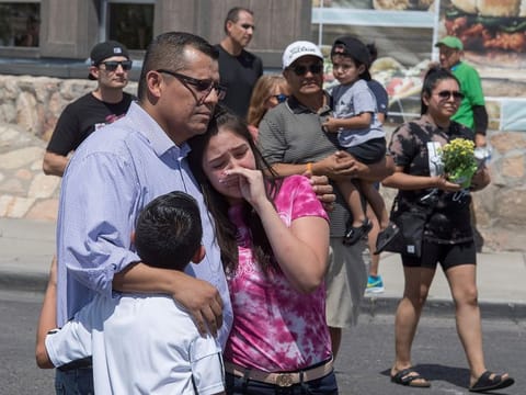 Members of the Medina family react beside a makeshift memorial outside the Cielo Vista Mall Wal-Mart (background) where a shooting left 20 people dead in El Paso, Texas, on August 4, 2019.