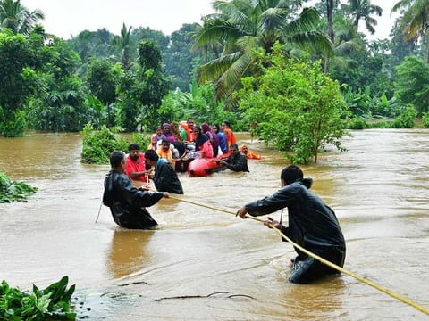 Rescue personals evacuate families affected by floods at Eloor, in Ernakulam district, in the Indian state of Kerala.