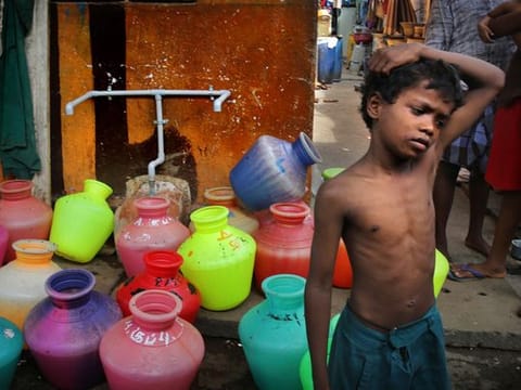 A boy waits at a water distribution point in Chennai, capital of the southern Indian state of Tamil Nadu. 