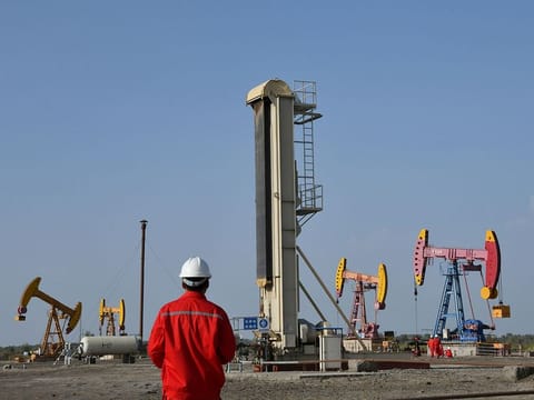 File photo: Workers are seen near pumpjacks at a China National Petroleum Corp (CNPC) oil field in Bayingol, Xinjiang Uighur Autonomous Region, China. 