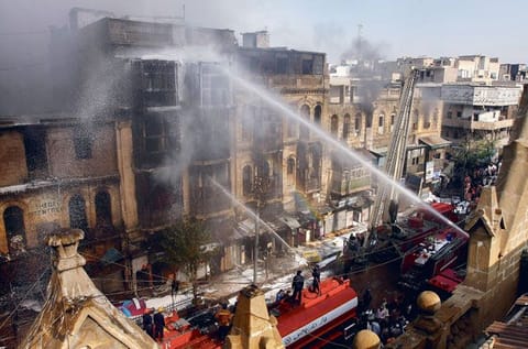 Firefighters battle a blaze in a building in Karachi. The force will get 50 new fire engines in January 2021.