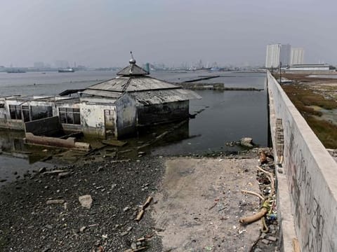 An submerged mosque next to a giant sea wall in northern Jakarta. Indonesia's capital is being swallowed into the ground at such an alarming rate that experts warn much of it could be submerged by 2050.