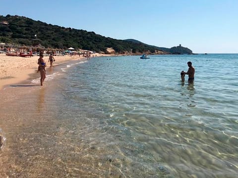 People enjoy the white sand and pristine waters of Chia beach, on the Italian island of Sardinia, Italy. 
