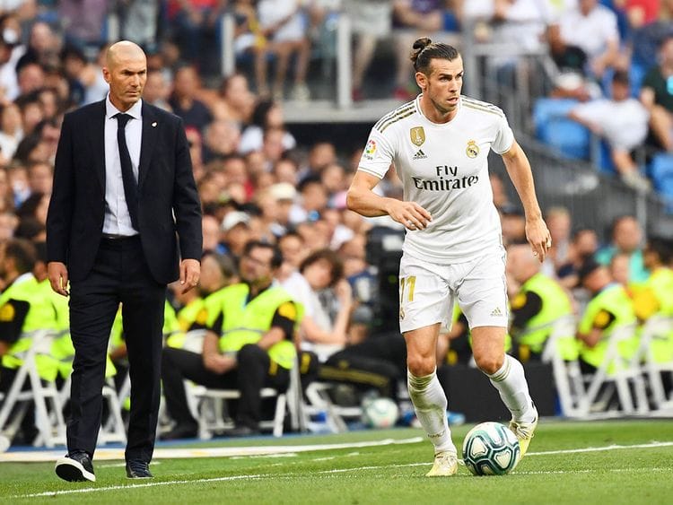 Real Madrid's coach Zinedine Zidane (L) looks at forward Gareth Bale 