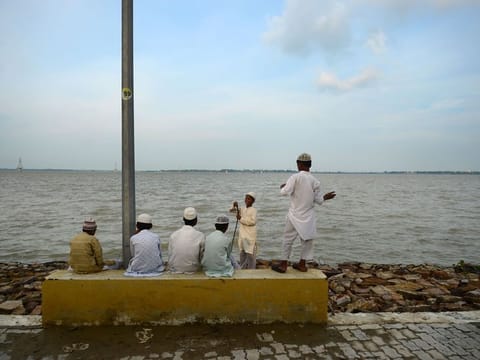 Indian Muslim students of a religious school or Madrasa sit on the bank of river Ganges as flood waters receded at the Sangam area in Allahabad on August 25, 2019