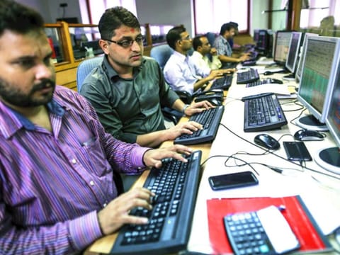 Employees work at computers at a brokerage firm in Mumbai, India. Indian stocks advanced in volatile trading a day after the benchmark gauge plunged the most in six years, as banks helped counter declines in software exporters.