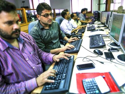 Employees work at computers at a brokerage firm in Mumbai, India. Indian stocks advanced in volatile trading a day after the benchmark gauge plunged the most in six years, as banks helped counter declines in software exporters.