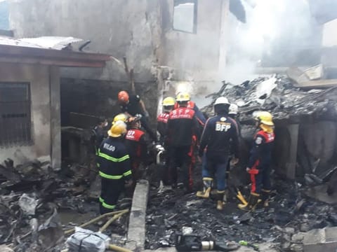 Filipino firefighters search for victims' bodies after a medical evacuation aircraft crash on a residential area in Barangay Pansol, Laguna., damaging two adjacent resorts. 