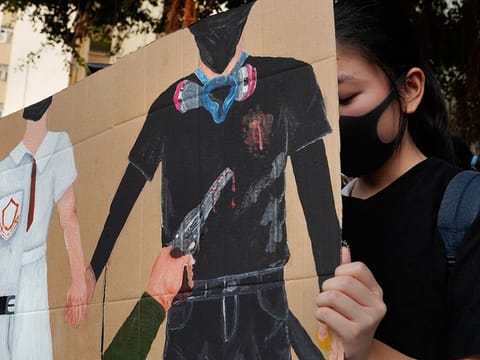 A supporter raises a printing featuring a protester shot in the chest by police during a strike in Hong Kong, Wednesday, October 2, 2019.  