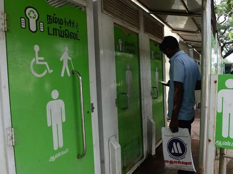 In this file photo taken on November 15, 2017 an Indian resident checks his phone as he waits to use a public toilet on a street in Chennai. India is to be declared "open-defecation free" by Prime Minister Narendra Modi on October 2, although experts question his bold claim that all 1.3 billion people in the country have access to a toilet.