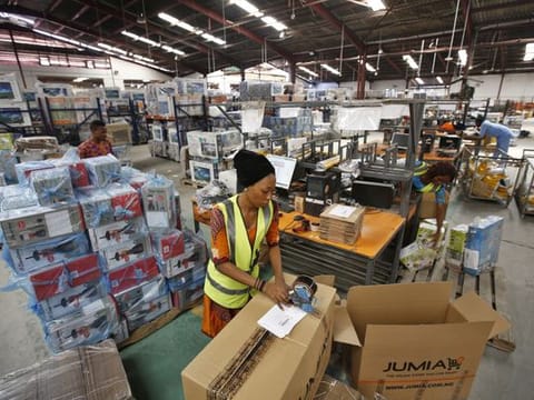 Bloomberg 

A worker packages goods inside branded cardboard boxes inside a Jumia distribution warehouse in Lagos.