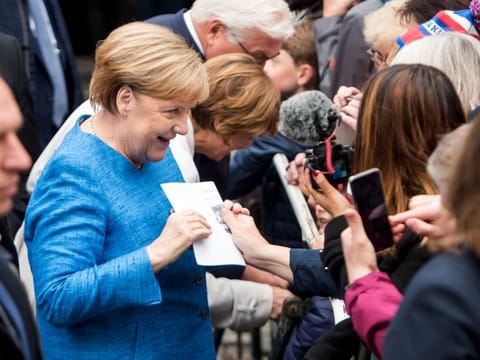 German Chancellor Angela Merkel receives a letter by a citizen ahead a ceremony on the German reunification in Kiel, on October 3, 2019.
