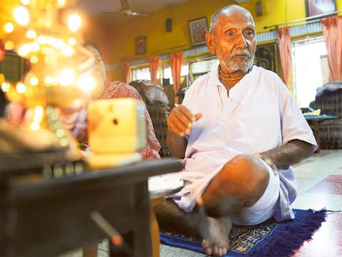 File photo: Swami Sivananda prays ahead of performing his morning stretches.