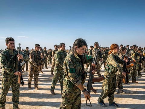 Kurdish fighters of the Syrian Democratic Forces in Hukumya, Syria, stand in formation during a funeral for comrades in this file picture. The SDF has begun withdrawing from the frontlines. 