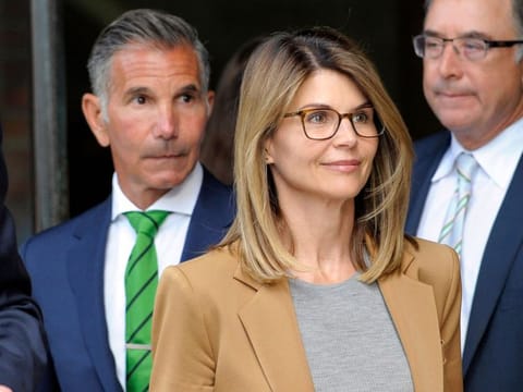 (FILES) In this file photo taken on April 03, 2019, ctress Lori Loughlin, with husband Mossimo Giannulli (L), exits the courthouse after facing charges for allegedly conspiring to commit mail fraud and other charges in the college admissions scandal at the John Joseph Moakley United States Courthouse in Boston.   Loughlin was slapped with an additional charge related to America's wide-ranging college admissions scandal on October 22, 2019, increasing the likelihood that she could serve time in prison. The star of 1980s-90s sitcom "Full House," her husband and nine other parents now face the charge of conspiracy to commit federal programs bribery on top of previous charges, prosecutors said. / AFP / Joseph Prezioso