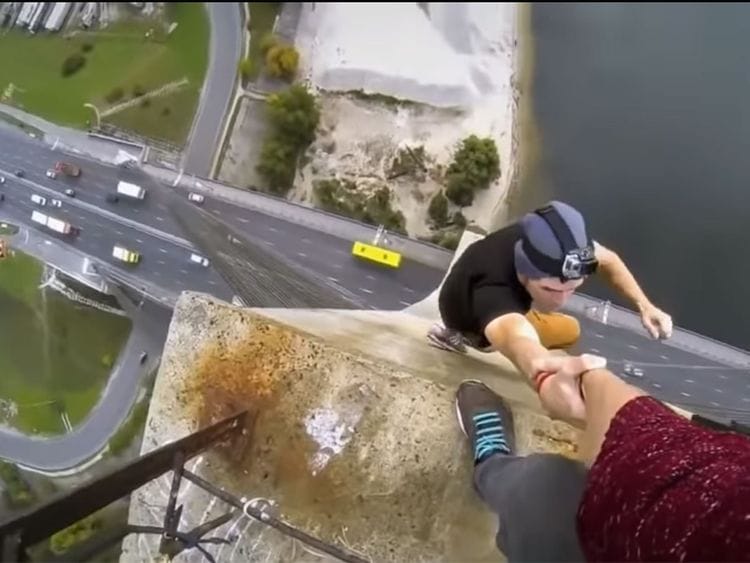 A selfie involving a man, being held by another person