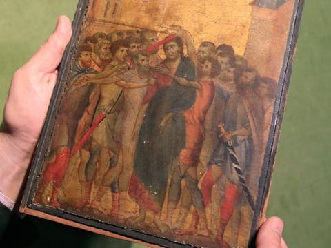 In this Tuesday, Sept. 24, 2019 file photo, art expert Stephane Pinta points to a 13th-century painting by Italian master Cimabue in Paris.