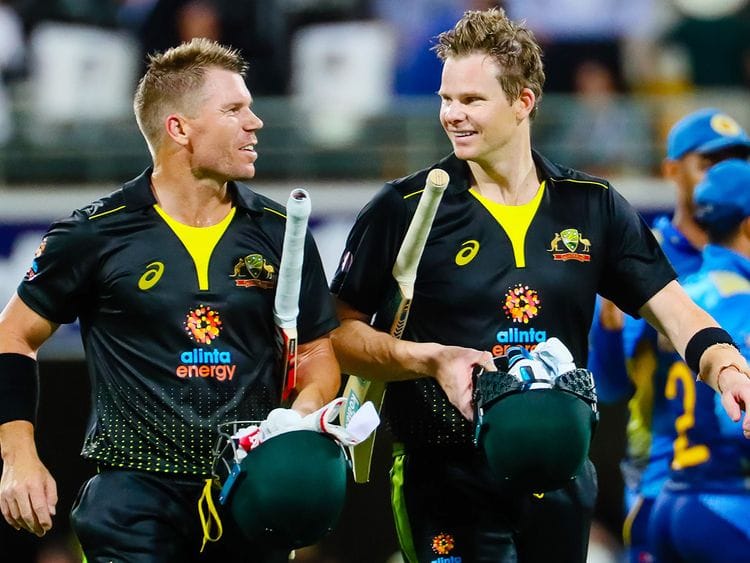 Australia's David Warner (L) speaks with Steve Smith