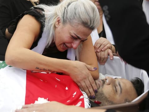 Lara, the wife of Alaa Abu Fakher, a man who killed by a Lebanese soldier on Tuesday night protests in southern of Beirut, mourns over her husband body during his funeral procession, in Choueifat neighborhood, Lebanon, Thursday, Nov. 14, 2019. 