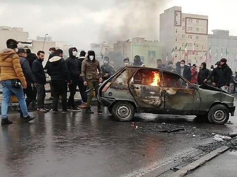 Iranian protesters gather around a burning car during a demonstration against an increase in gasoline prices in the capital Tehran last week.