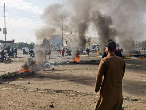 Smoke billows from burning tires during a demonstration in Nasiriyah, the capital of Iraq's southern province of Dhi Qar on November 24, 2019, as protesters cut-off roads and activists call for a general strike. 