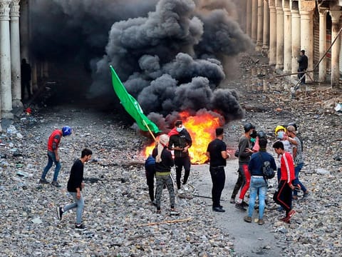 Anti-government protesters set fire while security forces close Rasheed Street during clashes in Baghdad, Iraq, Thursday, Nov. 28, 2019.