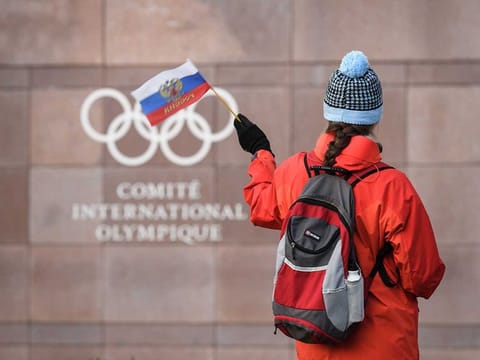 A supporter waves a Russian flag in front of the logo of the International Olympic Committee (IOC) at their headquarters in Pully near Lausanne.