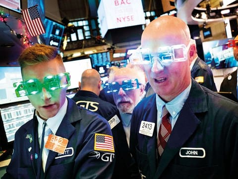 Traders wear New Year’s 2020 party glasses at the New York Stock Exchange on Tuesday. On Wall Street, the Dow Jones Industrial Average fell 29.73 points, or 0.1 per cent, to 28,432.41.