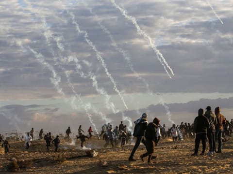 Tear gas canisters are fired by Israeli forces at Palestinians during a protest near the Israel-Gaza border fence, east of Rafah in the southern Gaza Strip, on December 27, 2019. 