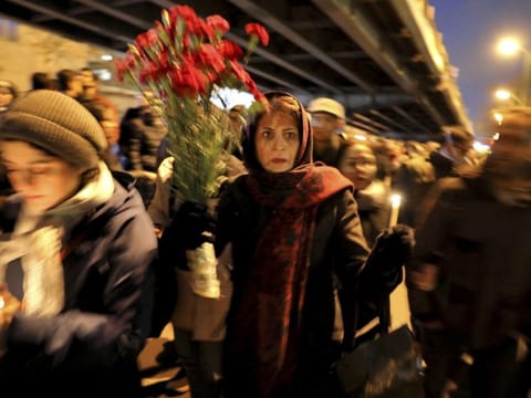 People gather for a candlelight vigil to remember the victims of the Ukraine plane crash, at the gate of Amri Kabir University  that some of the victims of the crash were former students of, in Tehran.