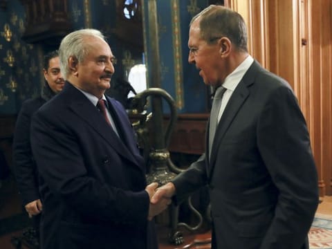In this handout photo released by Russian Foreign Ministry Press Service, Russian Foreign Minister Sergey Lavrov, right, shakes hands with Khalifa Haftar, the head of the Libyan National Army prior to talks in Moscow, Russia, Monday, Jan. 13, 2020. 