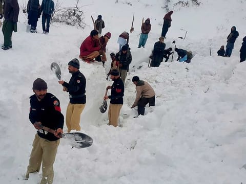 Police officers and local residents dig to search for bodies of victims of avalanches in Doodnail village in Neelum Valley, Kashmir, on Wednesday.