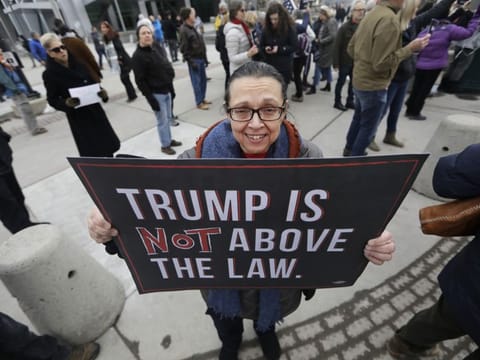 Marcie Hanks gathers with others outside the office of Sen. Mitt Romney to call on him to push for a full and fair impeachment trial in the Senate with pertinent testimony and evidence during a rally Thursday, Jan. 16, 2020, in Salt Lake City. 