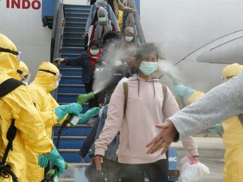 Indonesian students are disinfected as they disembark at the Hang Nadim international airport in Batam, following their evacuation from the Chinese city of Wuhan due to the coronavirus outbreak.