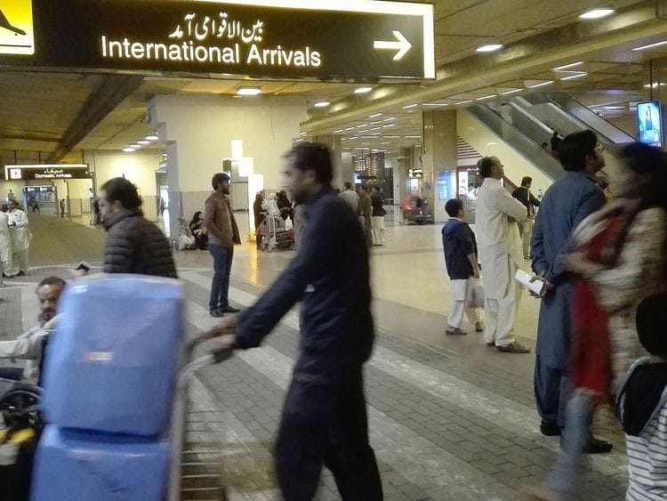 Passengers walk after  their arrival at the Jinnah International Airport in Karachi