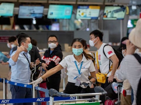 An airline staffer assists tourists from Wuhan, china, as they wait for a charter flight back to Wuhan at the Suvarnabhumi airport, Bangkok, Thailand.