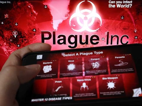 An advertisement for "Plague Inc.", a strategy simulation app that allows users to create and evolve a pathogen to destroy the world, is seen on a mobile phone screen in front of the logo of the game, in this illustration picture taken February 4, 2020. 
