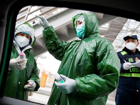 Medical workers and security personell stand at a checkpoint as the country is hit by an outbreak of the novel coronavirus in Anqing, Anhui province, China, on February 6, 2020.   
