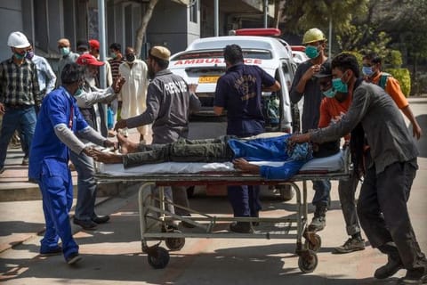 Paramedics personnel shift a patient on a stretcher into the hospital in Karachi on February 18, 2020, after a gas leak killed 7 people and sickened dozens of others in a coastal residential area in Pakistan's port city of Karachi.  / AFP / Rizwan TABASSUM