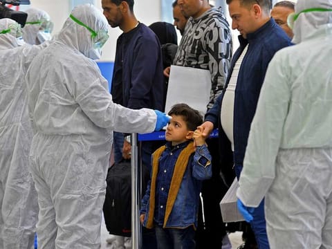 The body temperature of an Iraqi child returning from Iran is measured upon her arrival at the Najaf International Airport on February 21, 2020.