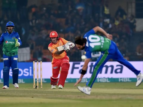 Multan Sultans' Shahid Afridi (R) attempts to catch the ball after a shot by Islamabad United's Luke Ronchi (C) during the Pakistan Super League (PSL) T20 cricket match between them at the Gaddafi Cricket Stadium in Lahore on February 22, 2020.  