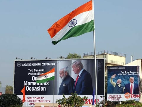 The Indian flag flies in front of billboards featuring images of Indian Prime Minister Narendra Modi and US President Donald Trump in Ahmedabad, India, on February 23, 2020. 