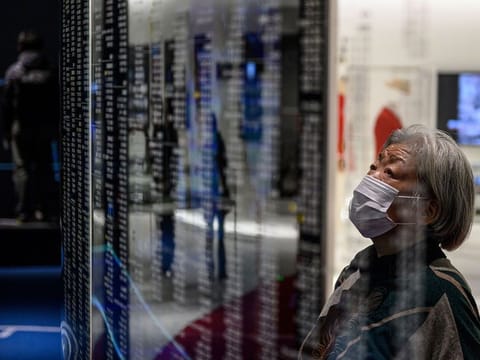 A visitor wearing a face mask, amid concerns over the spread of the COVID-19 novel coronavirus, visits the Japan Olympic Museum in Tokyo on February 26, 2020. 