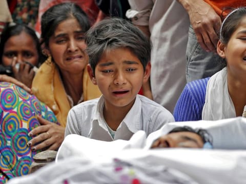People mourn next to the body of Muddasir Khan, who was wounded on Tuesday in a clash between people demonstrating for and against a new citizenship law, after he succumbed to his injuries, in a riot affected area in New Delhi, on February 27.