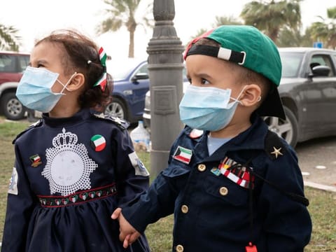 Kuwaiti kids wear protective face masks, following the outbreak of coronavirus, during celebrations of the 29th Kuwait Liberation Day from the Iraqi occupation, in Kuwait on February 26.