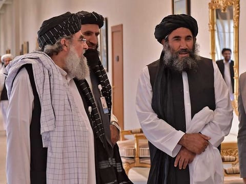 Mullah Abdul Salam Zaeef (2nd-R), senior official of the Afghan Taliban, alongside delegate members in Doha for Afghan peace talks