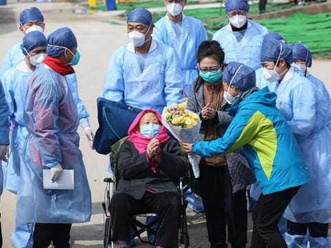 A recovered patient (C in wheelchair), 98, is discharged from Leishenshan Hospital, the makeshift hospital for the COVID-19 coronavirus patients, in Wuhan in China's central Hubei province on March 1, 2020.