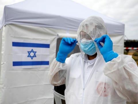 A paramedic adjusts his protective suit as he prepares outside a special polling station set up by Israel's election committee so Israelis under home-quarantine, such as those who have recently travelled back to Israel from coronavirus hot spots can vote in Israel's national election, in Ashkelon, Israel March 2.